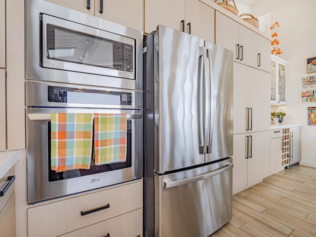 kitchen featuring appliances with stainless steel finishes, light hardwood / wood-style floors, and white cabinets