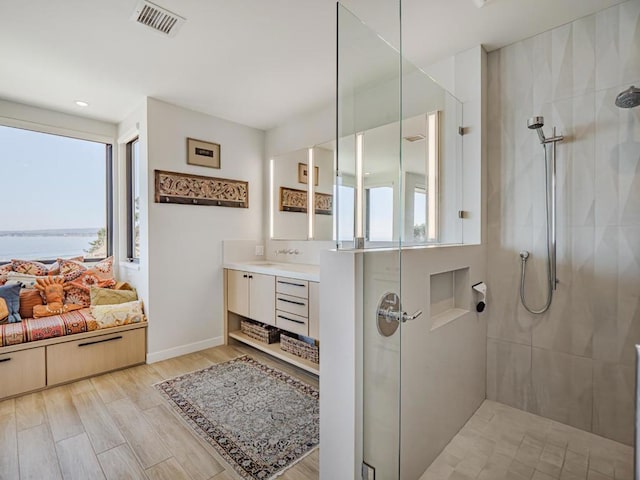 bathroom featuring vanity, hardwood / wood-style flooring, plenty of natural light, and a water view