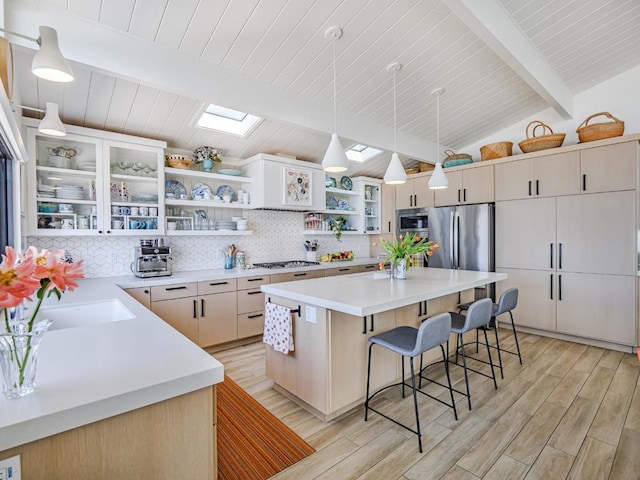 kitchen featuring pendant lighting, a breakfast bar area, backsplash, stainless steel appliances, and a center island