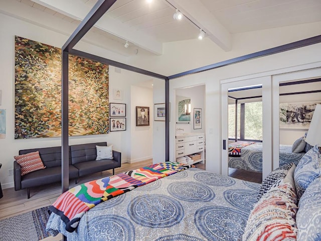 bedroom with hardwood / wood-style floors and vaulted ceiling with beams