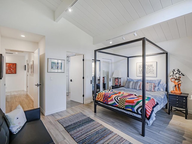 bedroom with wood ceiling, track lighting, light wood-type flooring, and vaulted ceiling with beams