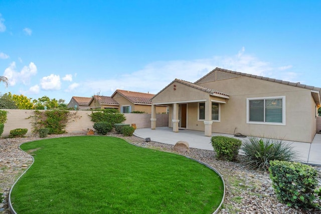 rear view of property featuring a yard and a patio