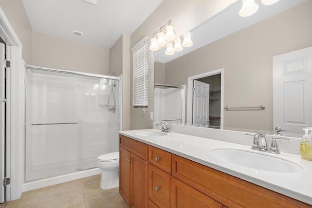 bathroom featuring a shower with shower door, vanity, tile patterned floors, and toilet