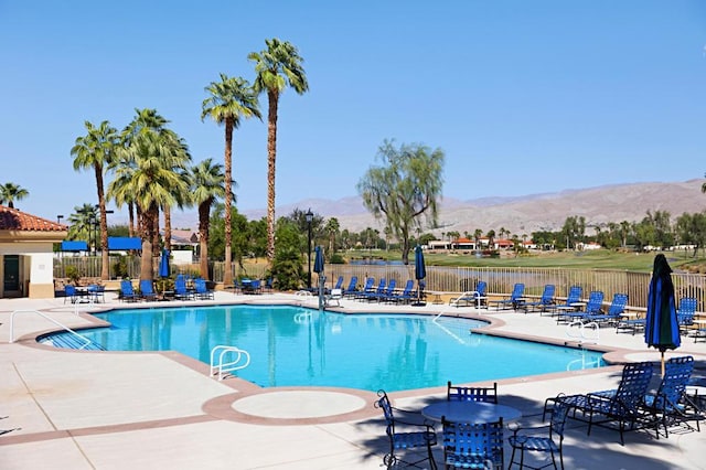 view of swimming pool with a patio area and a water and mountain view