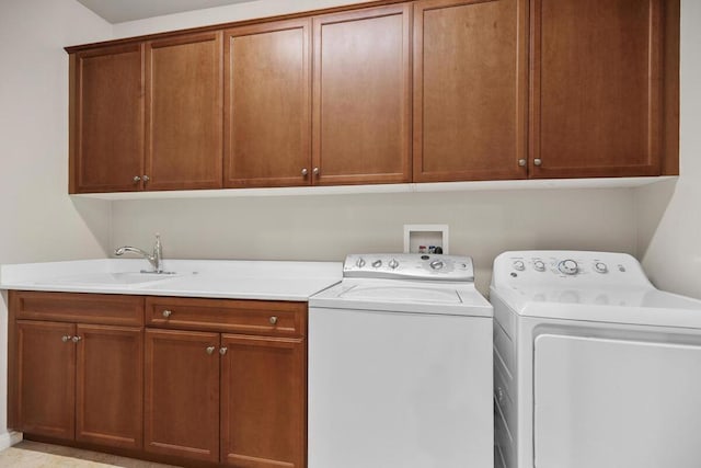 laundry area featuring cabinets, washer and clothes dryer, and sink