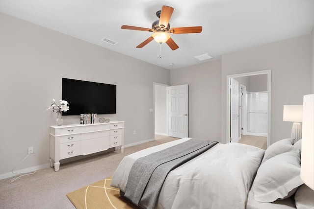 bedroom with ceiling fan, light carpet, and ensuite bath