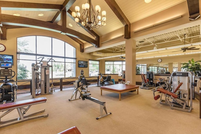 exercise room with high vaulted ceiling, carpet floors, and ceiling fan with notable chandelier