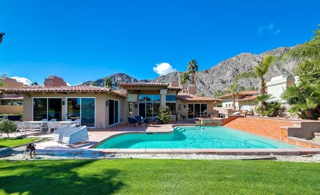 view of pool with a mountain view, a patio area, and a yard