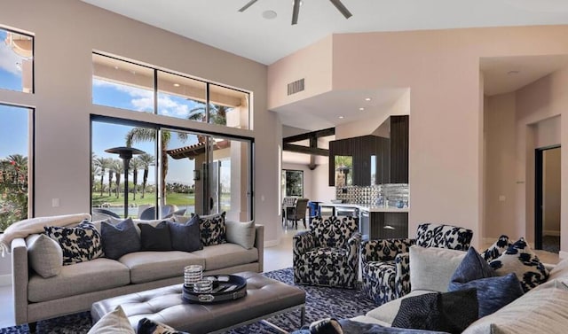 living room with ceiling fan and a high ceiling