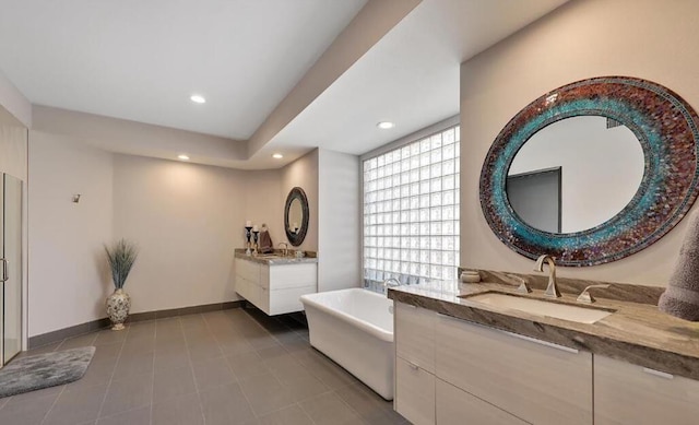 bathroom with a tub, tile patterned floors, and vanity