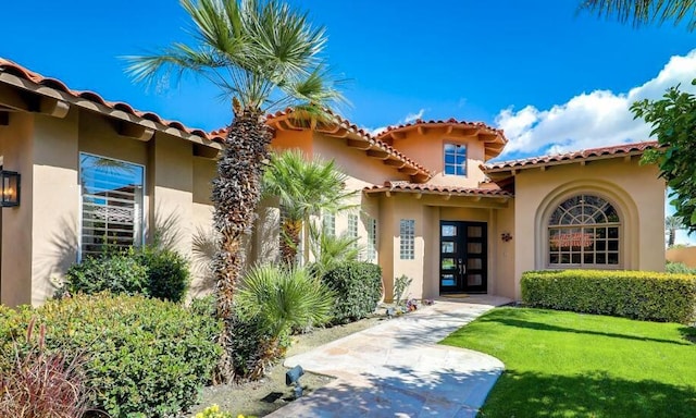 entrance to property with french doors and a yard