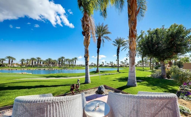 view of home's community with a water view and a lawn