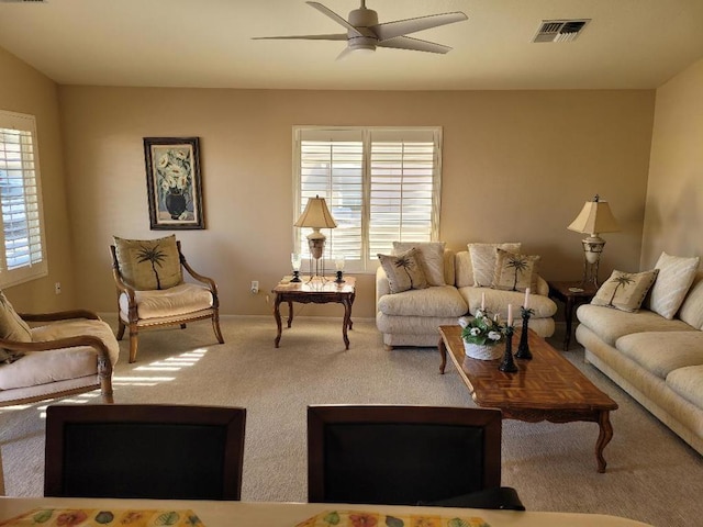 carpeted living room with ceiling fan