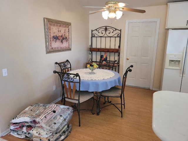 dining area with ceiling fan and light hardwood / wood-style floors