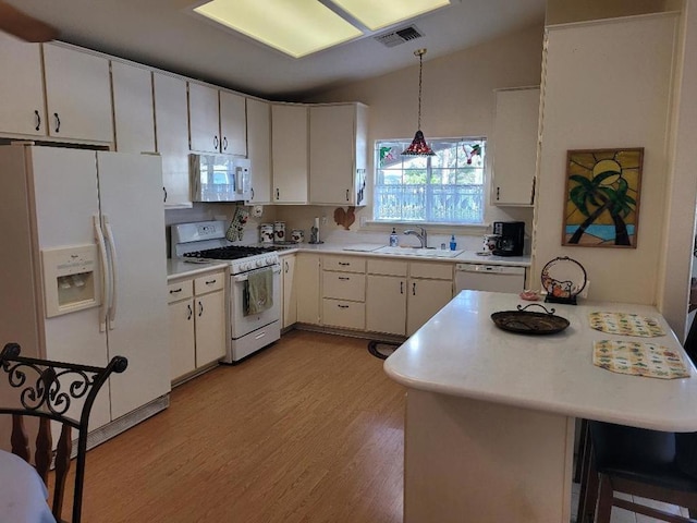 kitchen featuring white cabinetry, sink, kitchen peninsula, pendant lighting, and white appliances