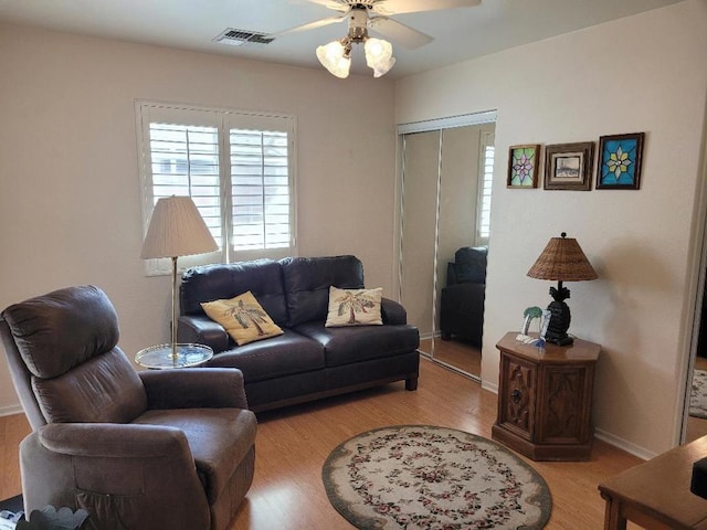 living room featuring light hardwood / wood-style flooring and ceiling fan