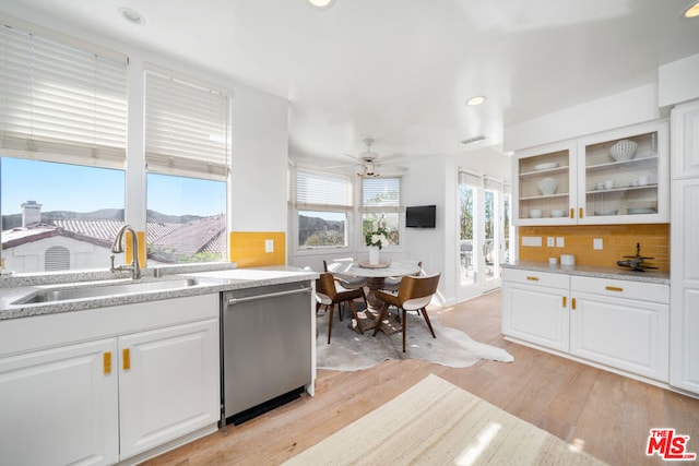 kitchen with backsplash, dishwasher, white cabinets, and light wood-type flooring