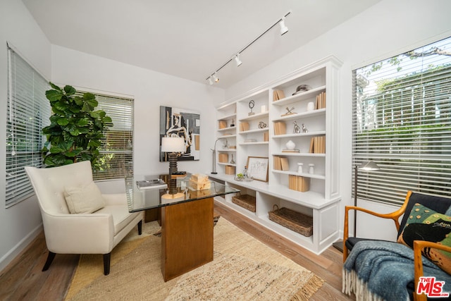 sitting room with light hardwood / wood-style floors and track lighting