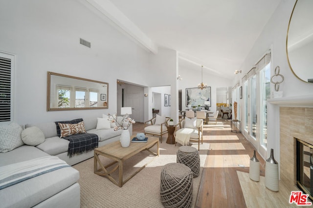 living room featuring light wood-type flooring, a healthy amount of sunlight, and a notable chandelier