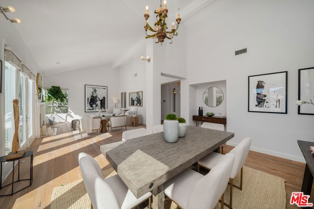 dining space with high vaulted ceiling, beamed ceiling, light hardwood / wood-style floors, and an inviting chandelier