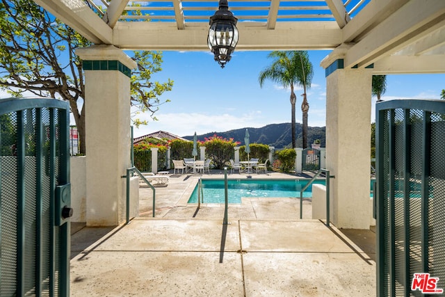 view of swimming pool featuring a pergola, a patio area, and a mountain view