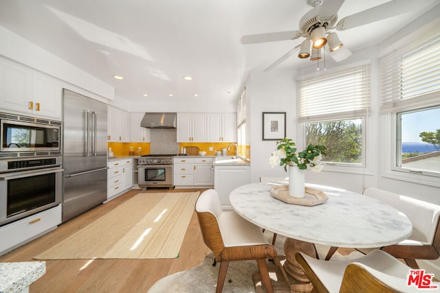 dining area with light hardwood / wood-style floors, ceiling fan, and sink