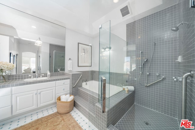 bathroom featuring tile patterned floors, vanity, and plus walk in shower