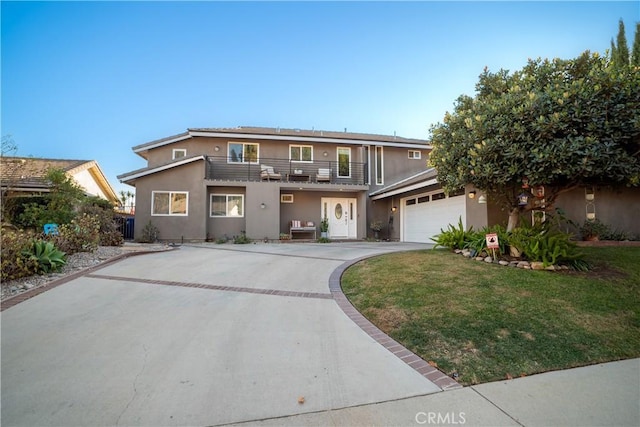 view of property featuring a front lawn, a balcony, and a garage