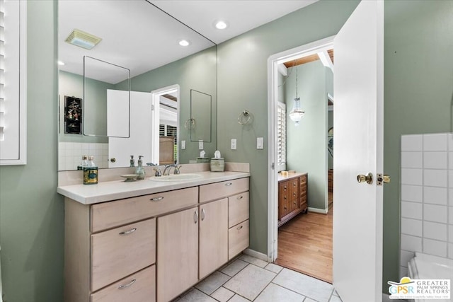 bathroom with backsplash, tile patterned flooring, and vanity