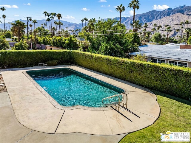 view of swimming pool featuring a mountain view and a patio