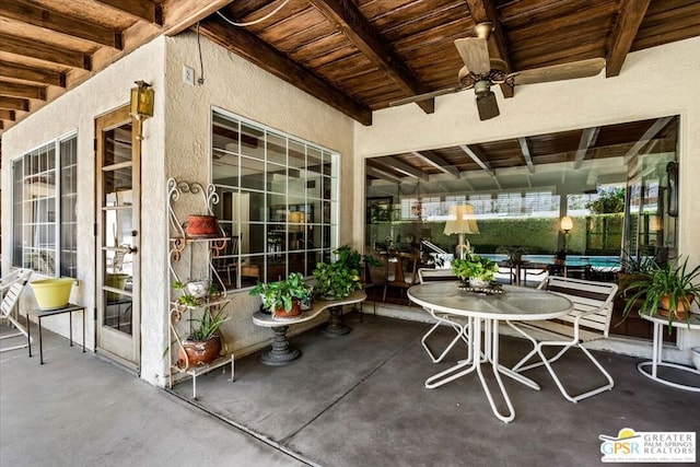 sunroom with beamed ceiling and ceiling fan