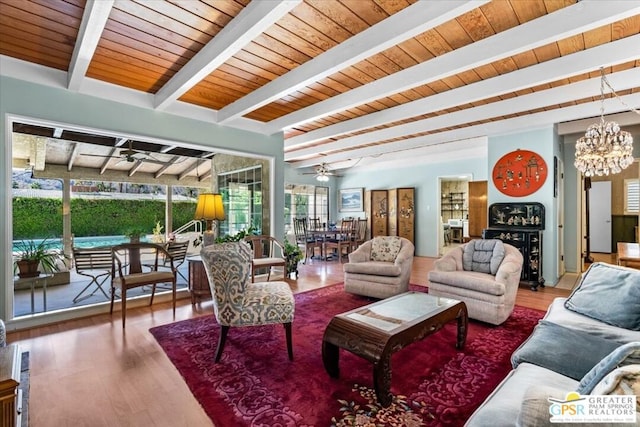 living room featuring hardwood / wood-style flooring, ceiling fan with notable chandelier, beam ceiling, and wood ceiling