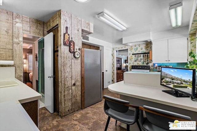 kitchen featuring stainless steel fridge and white cabinetry