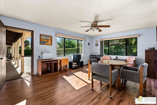 dining area featuring hardwood / wood-style flooring, ceiling fan, and a textured ceiling