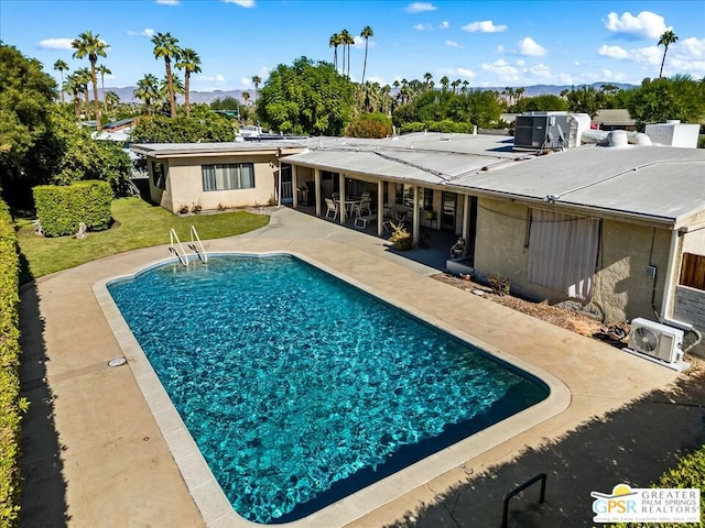 view of pool with ac unit and a patio