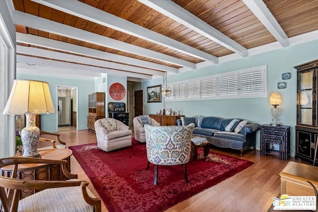 living room with beam ceiling, hardwood / wood-style flooring, and plenty of natural light