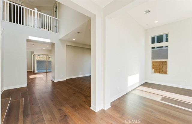 interior space with hardwood / wood-style floors and a high ceiling