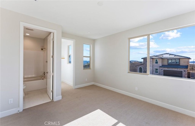 bedroom featuring light colored carpet and connected bathroom