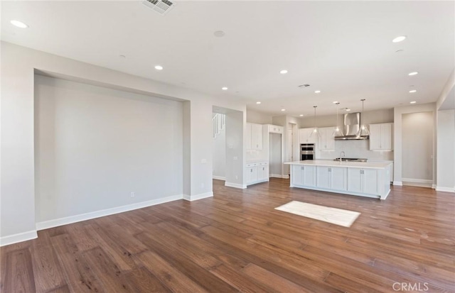 unfurnished living room featuring sink and dark hardwood / wood-style floors