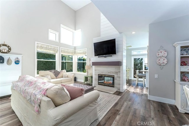 living room featuring plenty of natural light, a high ceiling, and hardwood / wood-style flooring