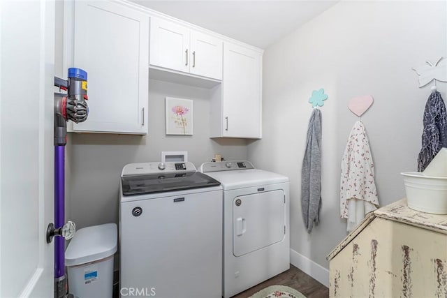 laundry area with cabinets, separate washer and dryer, and wood-type flooring