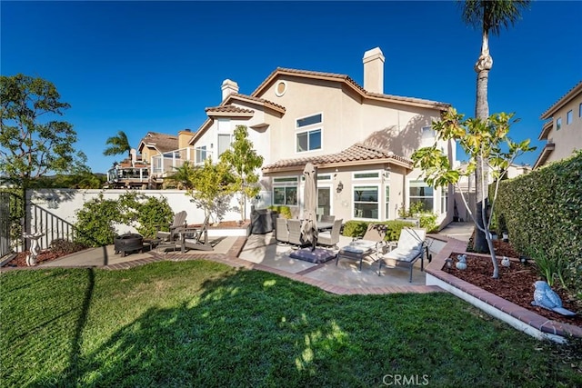 back of property with a lawn and a patio