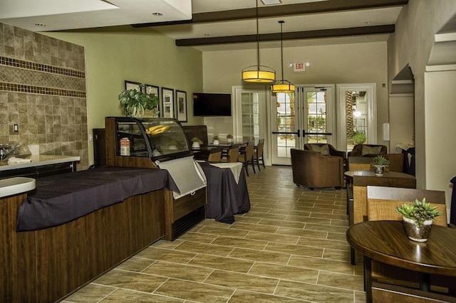 interior space featuring beamed ceiling, billiards, a high ceiling, and french doors