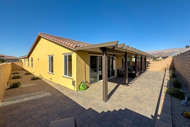 rear view of house with a mountain view and a patio area