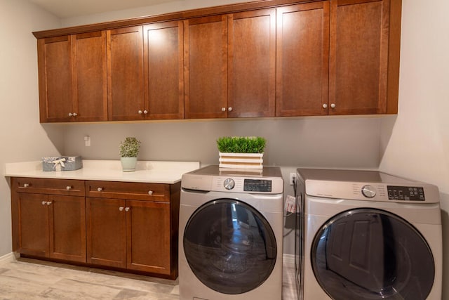 washroom with washer and clothes dryer and cabinets