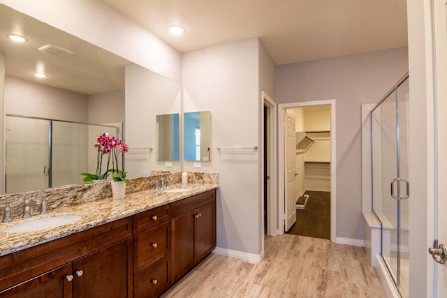 bathroom with hardwood / wood-style floors, vanity, and walk in shower