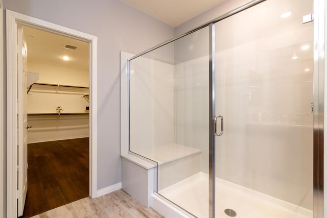 bathroom featuring hardwood / wood-style floors and a shower with shower door