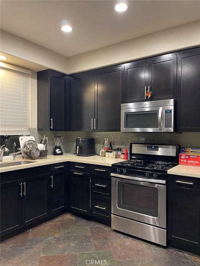 kitchen featuring stainless steel appliances, tasteful backsplash, and sink