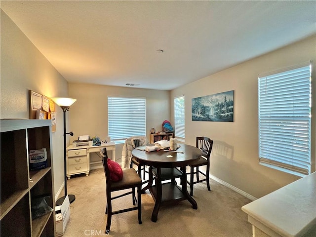 dining space featuring light carpet