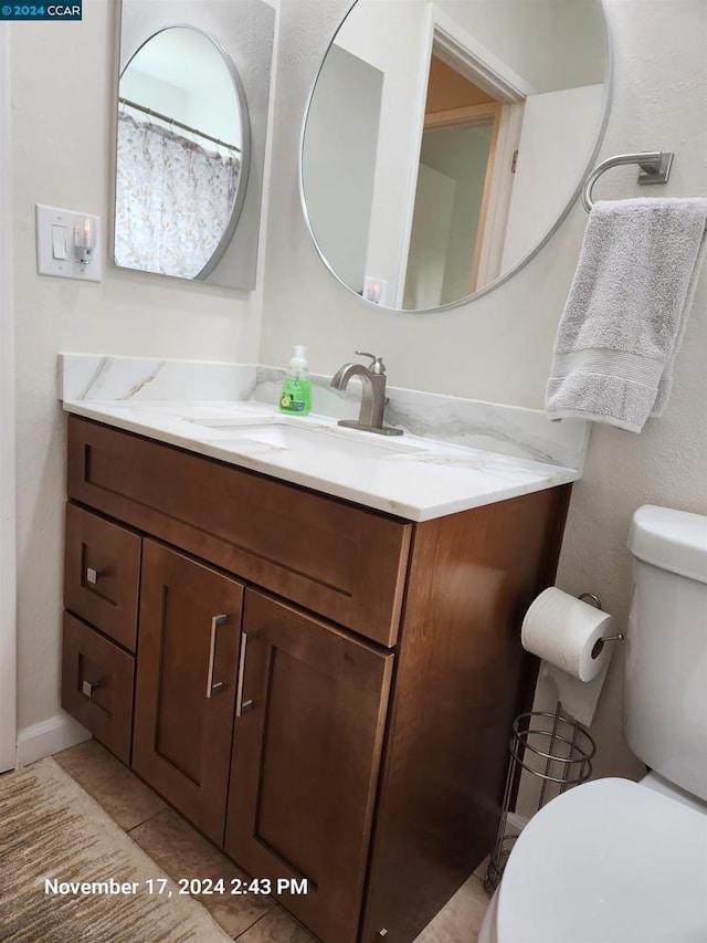 bathroom with tile patterned flooring, vanity, and toilet